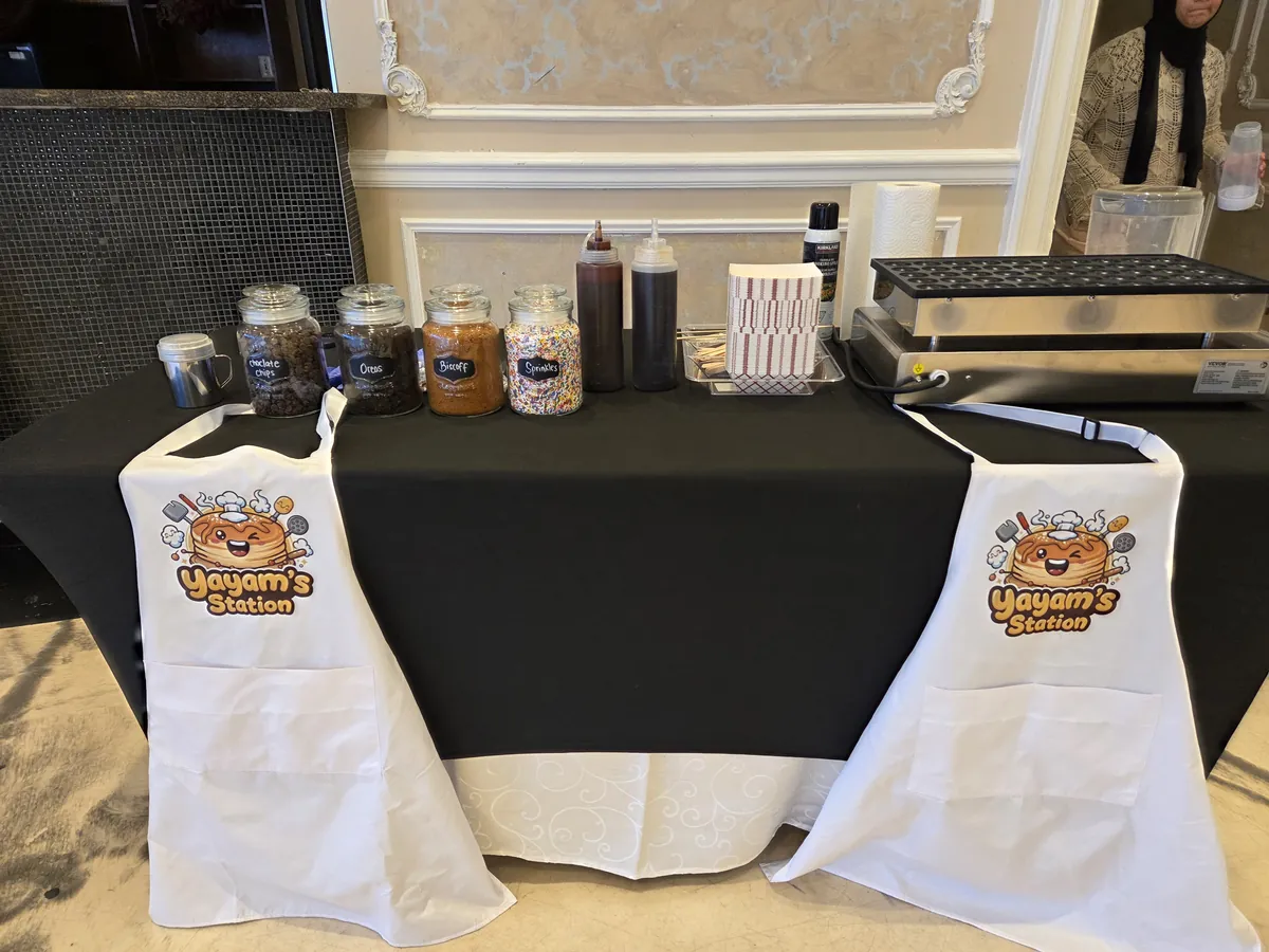 Yayam's Station dessert station with branded aprons, sauces and toppings jars in an event hall
