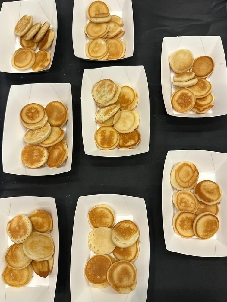 Fresh mini pancakes served in boats, ready for toppings